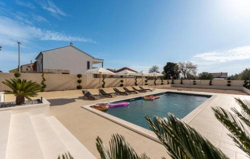 a swimming pool with lounge chairs in a backyard at Amazing Home In Biograd Na Moru in Biograd na Moru