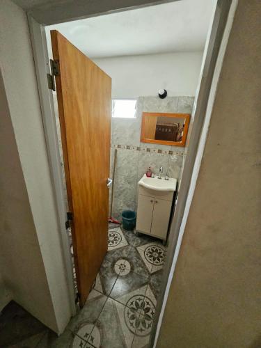 a small bathroom with a sink and a door at LUSANYUN 1 in Villa Independencia