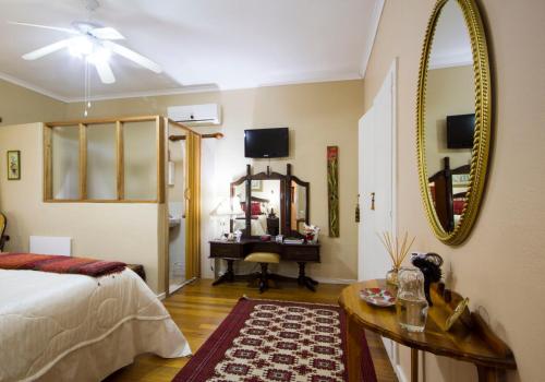 a bedroom with a bed and a mirror and a desk at Beau & I in Graaff-Reinet