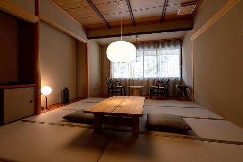 a room with a table and chairs and a window at くらま温泉 in Kyoto