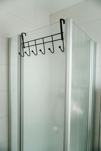 a shower in a bathroom with a shower curtain at Ferienwohnung KÖÖK Küstentraum - Modern, Balkon, Strandnah, Maisonette in Neuharlingersiel