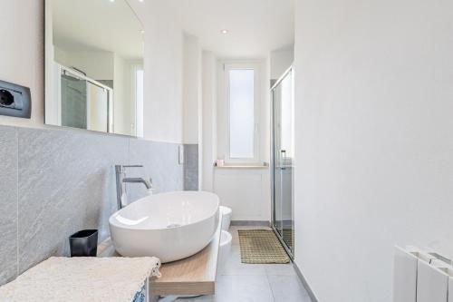 een badkamer met een wit bad en een wastafel bij Residenza Matteotti in Cuneo
