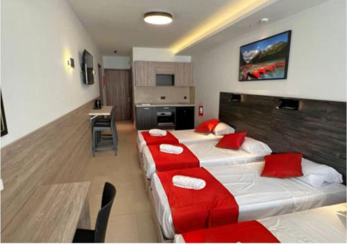 a hotel room with two beds with red pillows at Bayside A Apartments in St Julian's