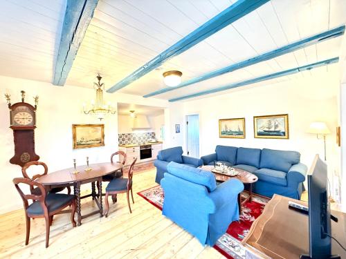 a living room with a blue couch and a table at Det Danske Hus - Wohnung Backbord in Dunsum
