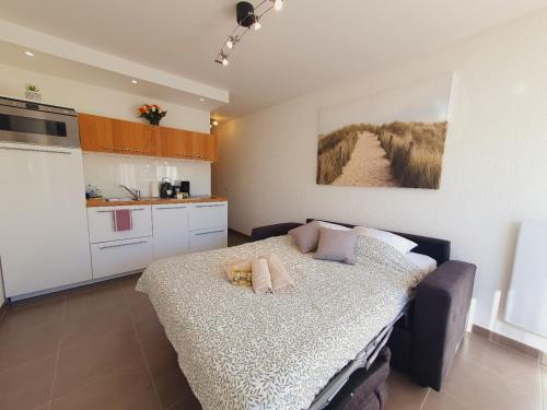 une chambre avec un lit et une cuisine dans l'établissement T2 Magellan Parking privé WIFI - Centre-ville - ROSSIconciergerie - Linge en option, à La Grande Motte