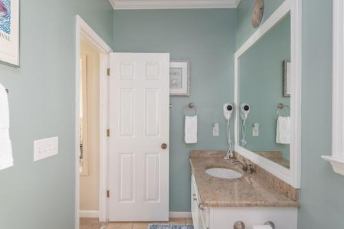a bathroom with a sink and a mirror at Shipwatch Beach House - Ocean Views! Shared Pool! in Cedar Reef Villas