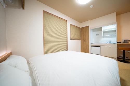 a bedroom with a white bed and a window at YADO TENKU Kyoto Nijo in Kyoto