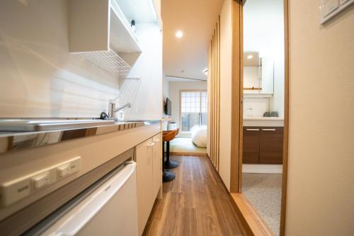 a kitchen with wooden floors and white cabinets at YADO TENKU Kyoto Nijo in Kyoto
