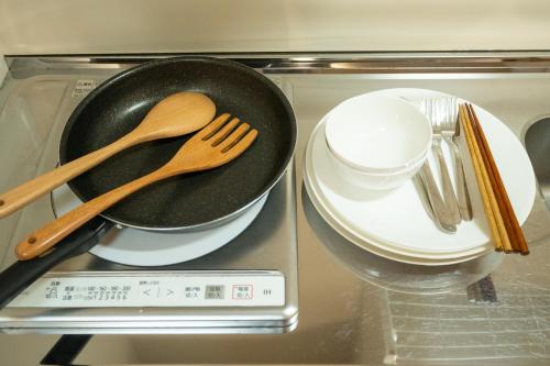 a frying pan and plates and utensils in an oven at YADO TENKU Kyoto Nijo in Kyoto