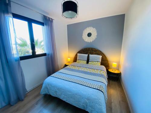 une chambre avec un lit avec une couette bleue et une fenêtre dans l'établissement Magnifique appartement vue mer et montagne à Solenzara Corse, à Sari-Solenzara