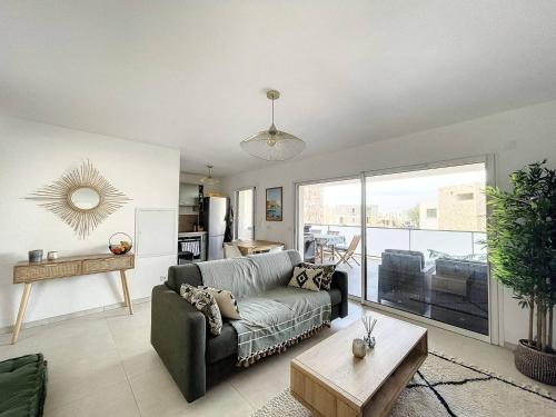 un salon avec un canapé et une table dans l'établissement Appartement dans résidence avec piscine, à Calvi