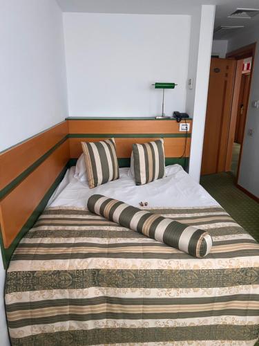 a bed with a wooden headboard and pillows on it at Hotel Jasmine in Braşov