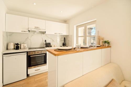 une cuisine blanche avec des armoires blanches et une fenêtre dans l'établissement Charming apartment - 2BD 4P - Center of St Tropez, à Saint-Tropez