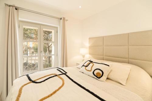 une chambre blanche avec un lit avec une fenêtre dans l'établissement Charming apartment - 2BD 4P - Center of St Tropez, à Saint-Tropez