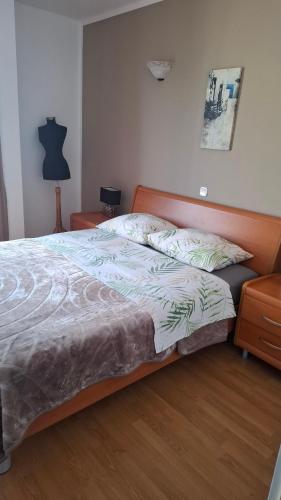 a bedroom with a large bed with a wooden headboard at Apartments Kimm's Hideaway in Poreč