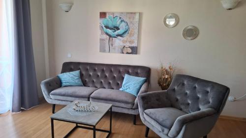 a living room with two chairs and a couch at Apartments Kimm's Hideaway in Poreč