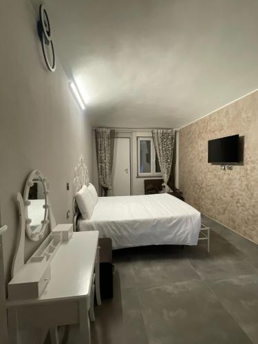 a bedroom with a bed and a desk and a mirror at airport apartments camera narciso in San Maurizio Canavese