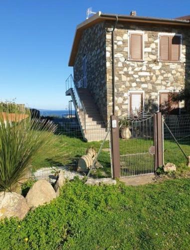 a stone house with a fence in front of it at La Pelosa House 1 in Stintino