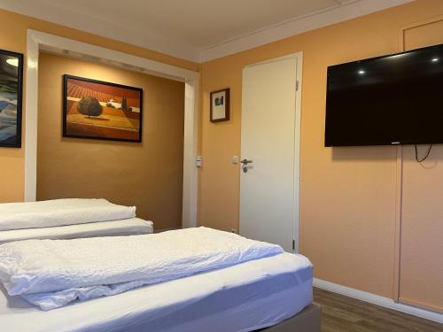 a hotel room with two beds and a flat screen tv at Hotel Quickborner Hof in Quickborn