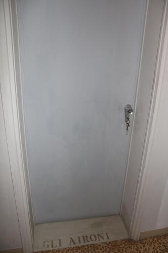a white door with a sign that says call autism at Art b&b Gli Aironi in Pomposa