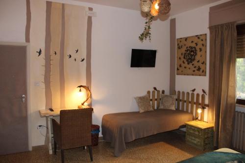 a bedroom with a bed and a desk with a lamp at Art b&b Gli Aironi in Pomposa