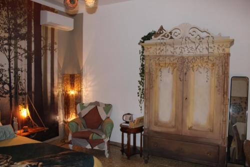 a bedroom with a bed and a cabinet and a chair at Art b&b Gli Aironi in Pomposa