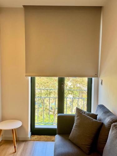a living room with a couch and a window at RIACENTRUM - Smart Residence in Aveiro