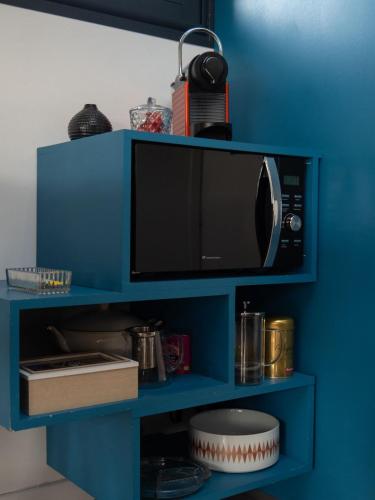 a blue shelf with a microwave on top of it at Appartement sur les toits, très jolie vue Provence in Gréoux-les-Bains