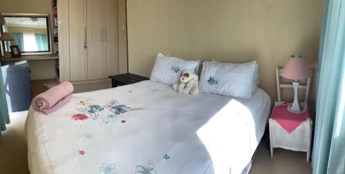 a teddy bear sitting on top of a bed at Scherers Ecke in Hentiesbaai