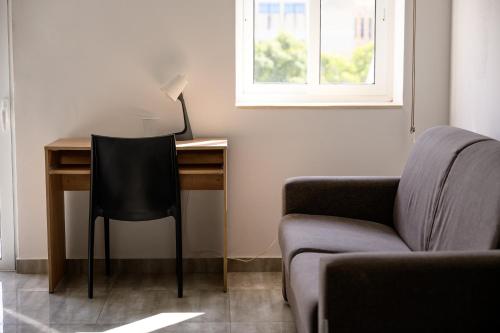 a desk in a room with a chair and a lamp at F11 Room 1, Private double room with private bathroom in shared Flat in Msida