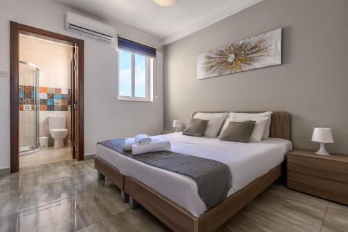 a bedroom with a large bed and a bathroom at F11 Room 1, Private double room with private bathroom in shared Flat in Msida