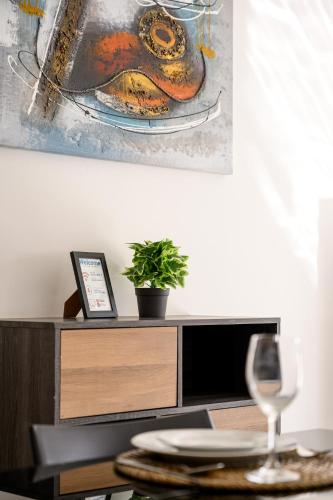 a table with a wine glass and a painting on the wall at F11 Room 1, Private double room with private bathroom in shared Flat in Msida