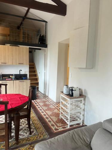 un salon avec une table et une cuisine dans l'établissement Adorable maison vue mer proche monaco, à La Turbie