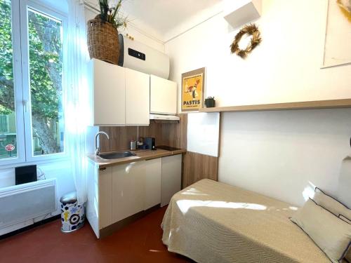 - une cuisine avec un lit et un évier dans la chambre dans l'établissement Studette downtown Pertuis, à Pertuis