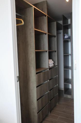 a closet with wooden shelves in a room at HOM I Acogedor y Cómodo depto de 1Dorm Vista al Mar PNM 0114 in Antofagasta