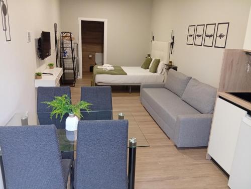 a living room with a couch and a bed at Ribera Home in Córdoba
