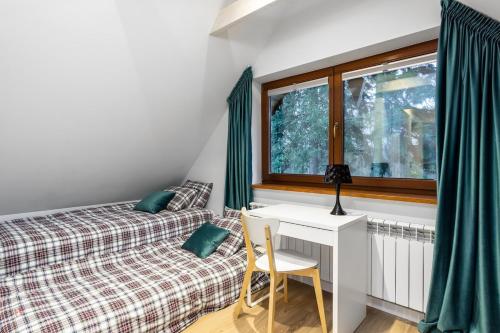 a bedroom with a bed and a desk and a window at Siedlisko przy Młynie in Cisze