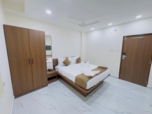 a bedroom with a bed and a wooden cabinet at Hotel Apex Inn Hyderabad Airport in Hyderabad