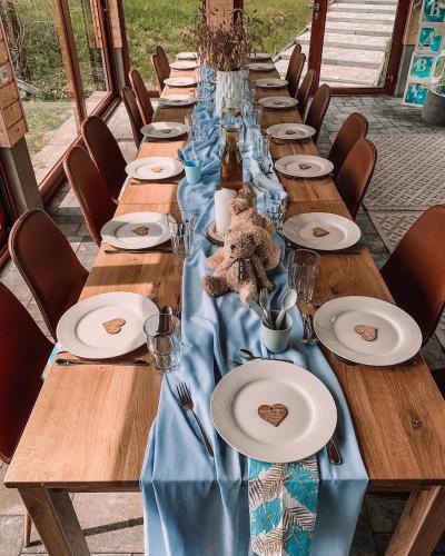 a long table with wooden tables with blue table cloth at Siedlisko przy Młynie in Cisze
