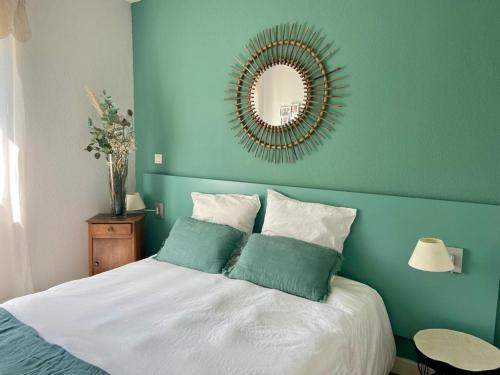 une chambre avec un lit avec un miroir au mur dans l'établissement La maison de Domi, à Montboucher-sur-Jabron