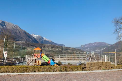 a playground with a slide in front of a mountain at Casa vacanze Le More in Cares