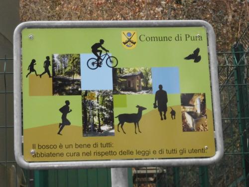 a sign on a fence with people on a bike at Casa la Selva in Pura