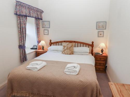 ein Schlafzimmer mit einem Bett mit zwei Handtüchern darauf in der Unterkunft Lavender Cottage in Wooler