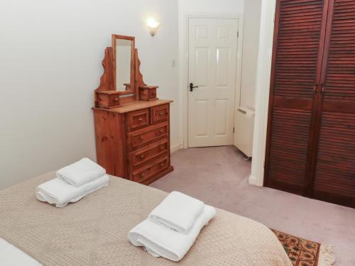 ein Schlafzimmer mit einem Bett, einer Kommode und einem Spiegel in der Unterkunft Lavender Cottage in Wooler