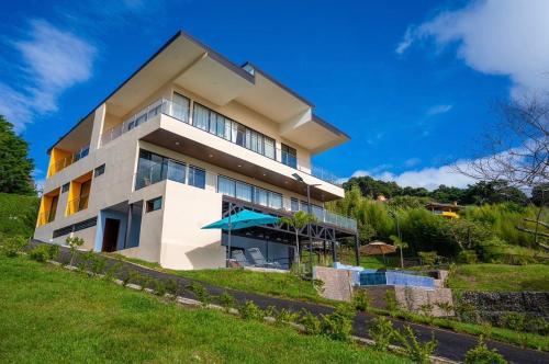 a large white building with a lawn in front of it at La Parada House in Heredia