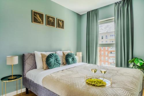 a bedroom with a bed with a tray of food on it at Lumina luxury 3-rooms apartments with parking in Łódź