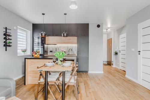 a kitchen with a wooden table and a dining room at Lumina luxury 3-rooms apartments with parking in Łódź