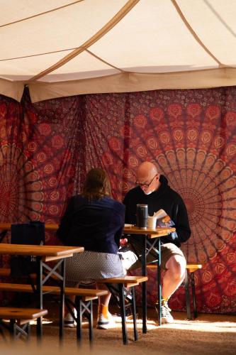 a man and a woman sitting at a table at Glamping at Hay Festival in Hay-on-Wye