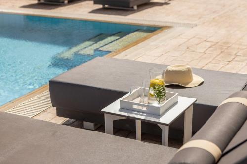 a hat sitting on a table next to a pool at Villa Protaras View 9 Central Protaras -Fig Tree Bay-Jacuzzi-Hot Tub in Protaras