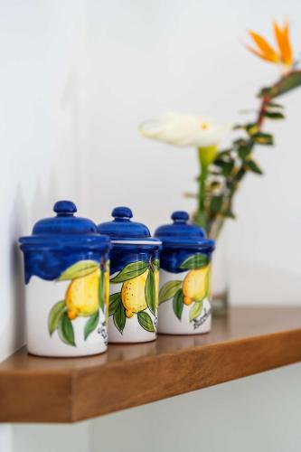 three bottles sitting on a shelf with a vase at L'antica Pigna Chateau in Vico Equense